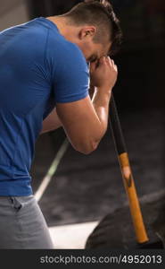 Sledgehammer Tire Hits young muscular man workout at gym with hammer and tractor tire