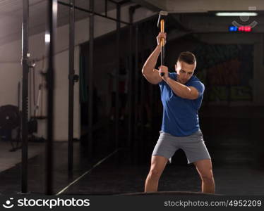 Sledgehammer Tire Hits young muscular man workout at gym with hammer and tractor tire