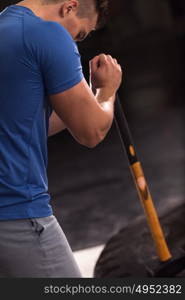 Sledgehammer Tire Hits young muscular man workout at gym with hammer and tractor tire