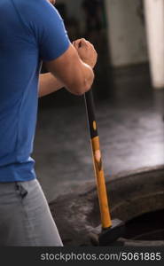 Sledgehammer Tire Hits young muscular man workout at gym with hammer and tractor tire