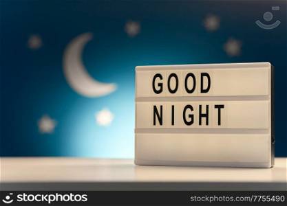 sleeping and bedtime concept - close up of customizable light box with good night words over moon and night stars on blue background. customizable light box with good night words