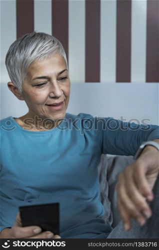 Sleeping Application - Beautiful Senior Woman in Bed, Checking Smart Watch Sleep Tracker Before Sleeping