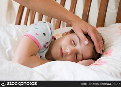 Sleeping girl with adult hand on her head