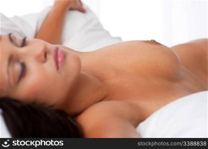 Sleeping naked woman in white bed, shallow DOF, focus on nipple, shallow DOF