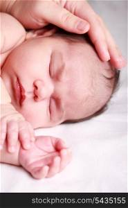 Sleeping newborn baby closeup face with mother hand