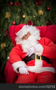 Sleeping Santa Clause on red Christmas armchair