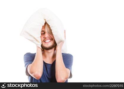 Sleeping well concept. Happy young man rested after good night sleep playing with downy cushion, laughing and having fun, isolated. Man playing with pillow, good sleep concept