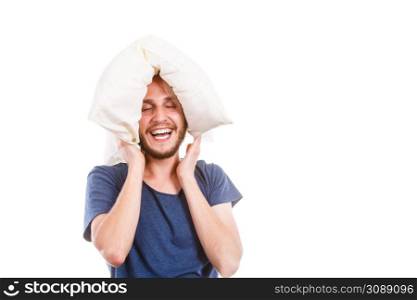 Sleeping well concept. Happy young man rested after good night sleep playing with downy cushion, laughing and having fun, isolated. Man playing with pillow, good sleep concept