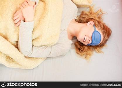 Sleeping woman wearing blindfold sleep mask.. Tired woman sleeping in bed under blanket wearing blindfold sleep mask. Young girl taking nap.