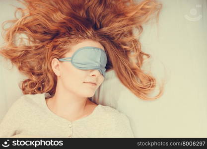 Sleeping woman wearing blindfold sleep mask.. Tired woman sleeping in bed wearing blindfold sleep mask. Young girl taking nap.