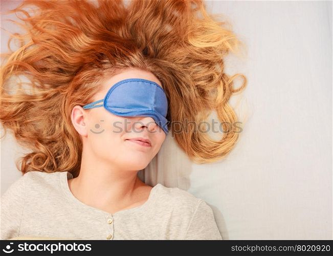 Sleeping woman wearing blindfold sleep mask.. Tired woman sleeping in bed wearing blindfold sleep mask. Young girl taking nap.