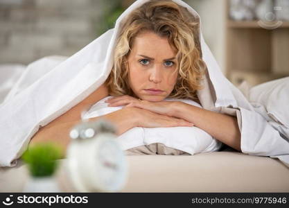 sleepless woman lying down on bed tired