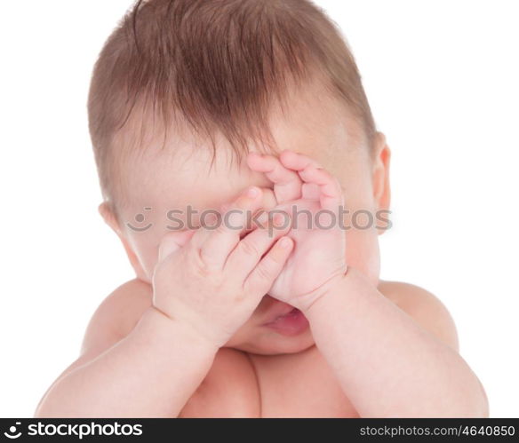 Sleepy baby covering the face with his hands isolated on a white background