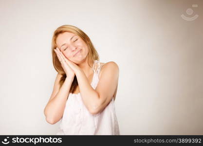 Sleepy blonde woman with no makeup, fresh face with natural make up, young female with lack of sleep, gray background