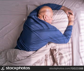 Sleepy old elderly black man yawning. African American people lying and sleeping on bed in bedroom in early morning at home. Lifestyle