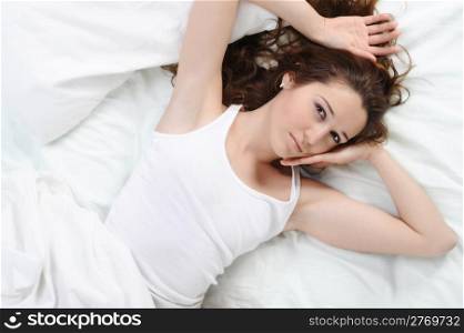 Sleepy woman turns off the alarm. Isolated on white background
