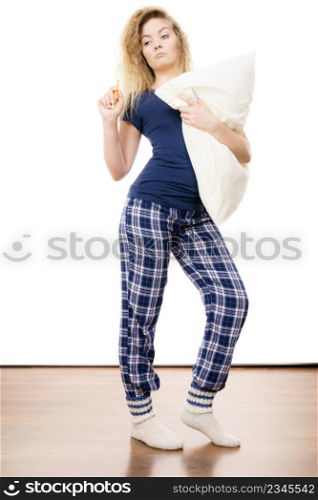 Sleepy woman wearing blue pajamas holding pillow, sleep outfit blue tshirt and checked trousers. Sleepy woman wearing pajamas