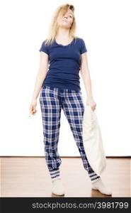 Sleepy woman wearing blue pajamas holding pillow, sleep outfit blue tshirt and checked trousers. Sleepy woman wearing pajamas