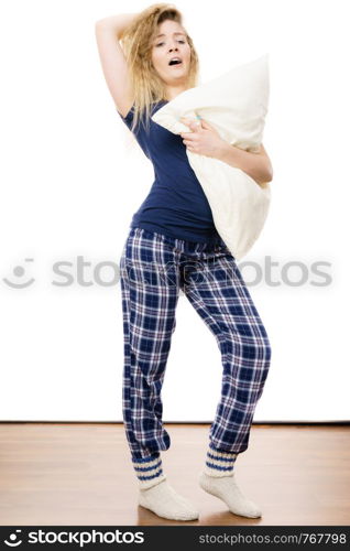 Sleepy woman wearing blue pajamas holding pillow, sleep outfit blue tshirt and checked trousers. Sleepy woman wearing pajamas