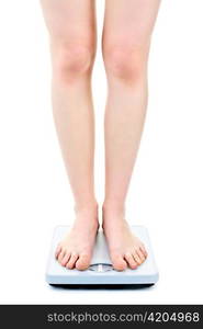 Slender female legs standing on bathroom scale