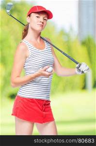Slender sportswoman golfer with stick and ball on a background of golf courses