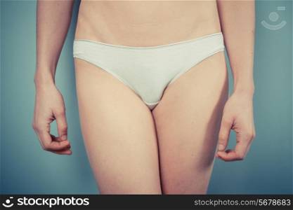 Slender woman with toned stomach wearing white underwear