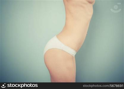 Slender woman with toned stomach wearing white underwear