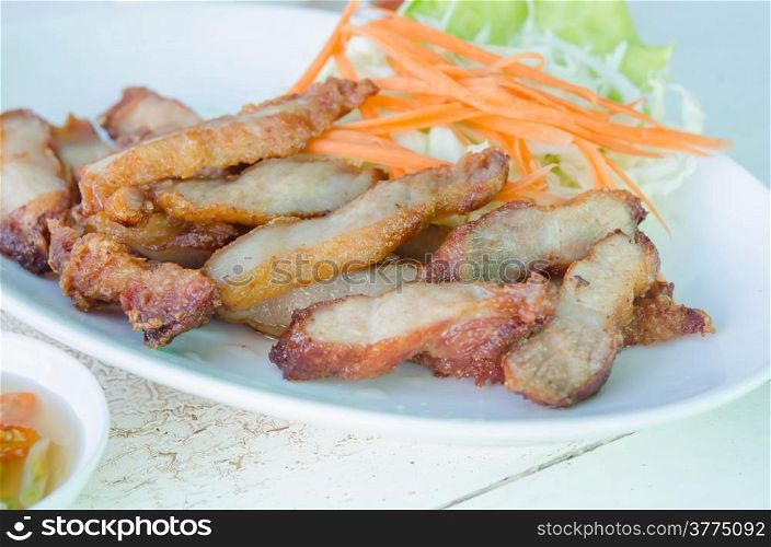 slice grilled pork served with fresh vegetable on dish. grilled pork