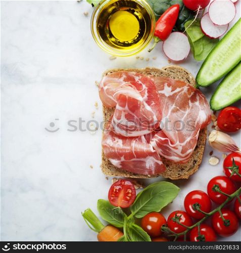 Slice of a whole wheat bread and healthy organic vegetables for making sandwiches. Healthy eating or cooking concept. Background layout with free text space.