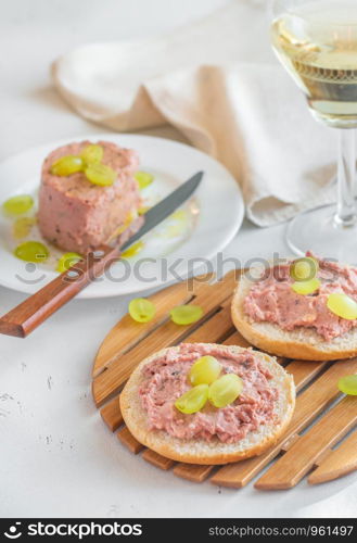 Slice of bread with pate with glass of wine on the wooden board