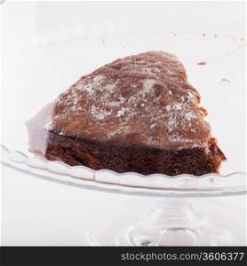 Slice of cake in a glass stand, square image