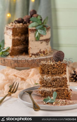 Slice of delicious naked chocolate and hazelnuts cake on table rustic wood kitchen countertop.