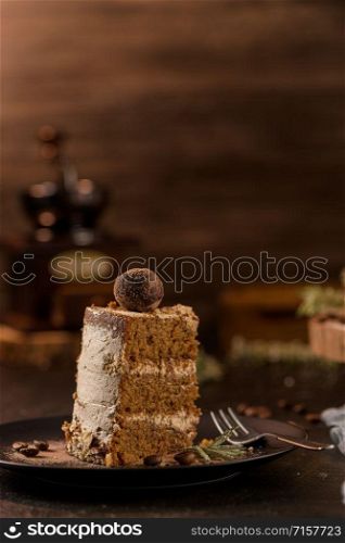 Slice of delicious naked coffee and hazelnuts cake on table rustic wood kitchen countertop.