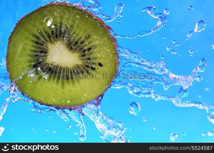 slice of kiwi in the water with bubbles on blue background