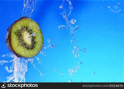 slice of kiwi in the water with bubbles, on blue background