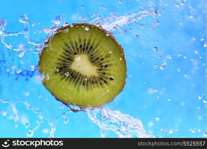 slice of kiwi in the water with bubbles on blue background