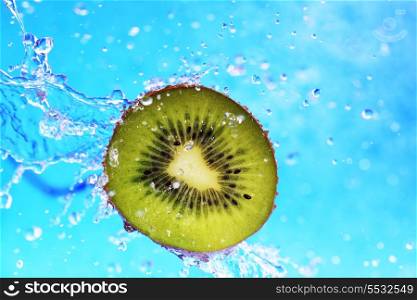 slice of kiwi in the water with bubbles on blue background