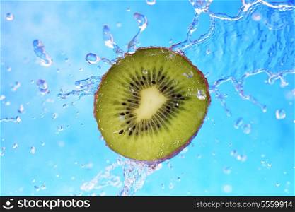 slice of kiwi in the water with bubbles on blue background