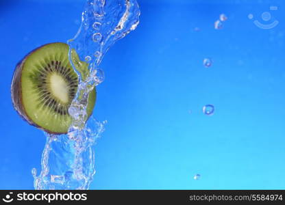 slice of kiwi in the water with bubbles, on blue background