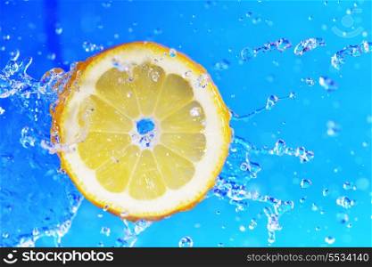 slice of lemon in the water with bubbles on blue background