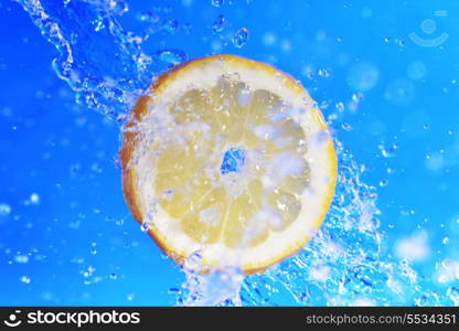 slice of lemon in the water with bubbles on blue background