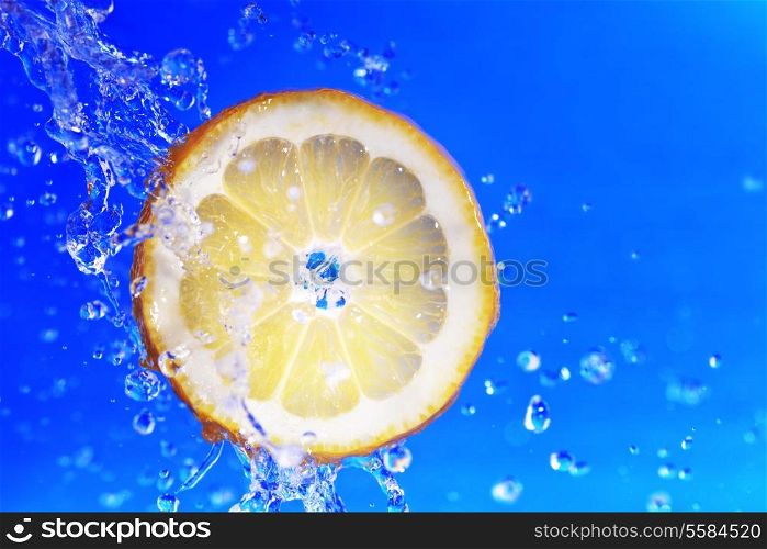 slice of lemon in the water with bubbles on blue background