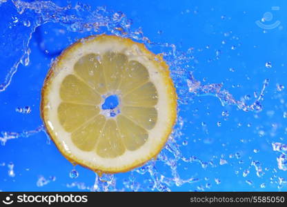 slice of lemon in the water with bubbles on blue background