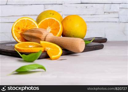 Slice of orange on wooden board with sharp knife. Fresh citrus orange fruits on cutting board for salad or juicing. Healthy eating, cooking, diet and summer concept