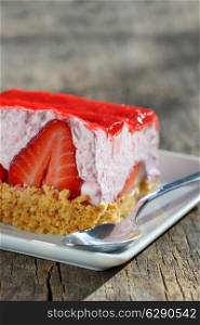 slice of strawberry cheesecake on wooden table