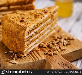 Slice of sweet honey cake on wooden board