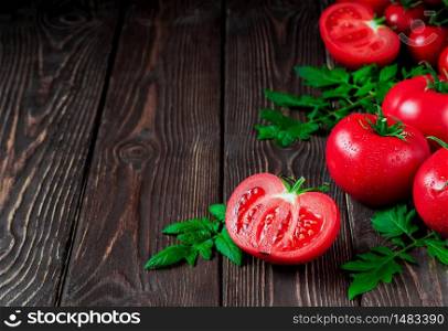 Slice of tomato and ripe red tomatoes close-up on a dark rustic background. Ripe vegetables from the market, ingredients for the preparation of salads or dishes. Copy space
