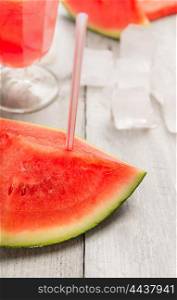 slice of watermelon with drink straw on drinks and ice background, close up