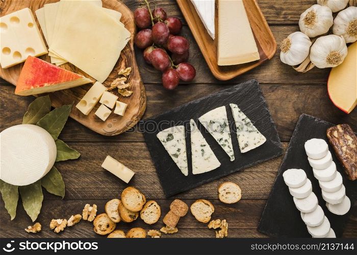 slice various chees with grapes bread slice walnut garlic desk