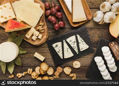 slice various chees with grapes bread slice walnut garlic desk
